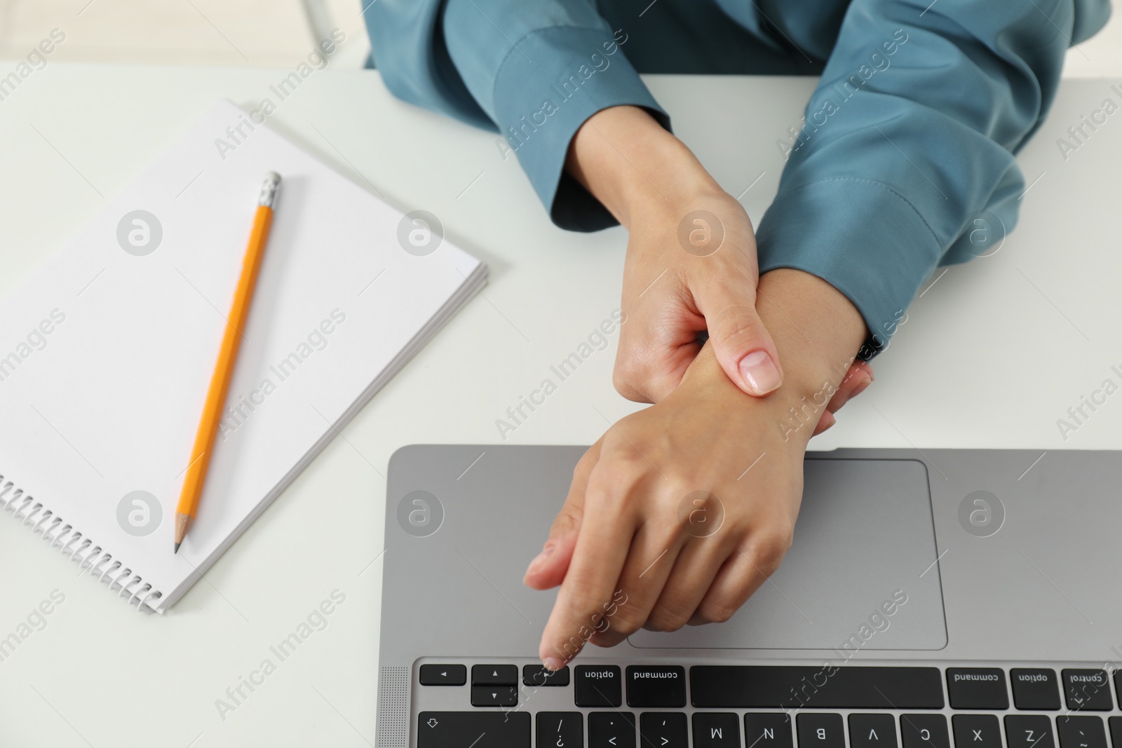 Photo of Carpal tunnel syndrome. Woman suffering from pain in wrist at desk, above view