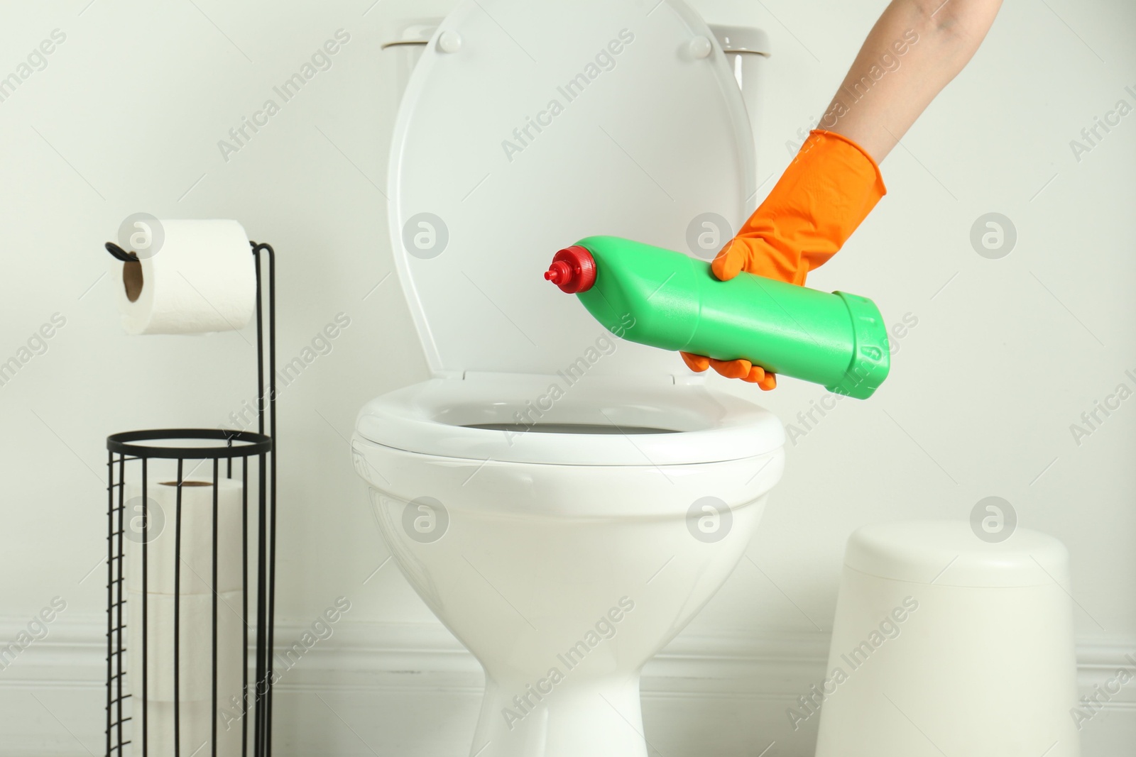 Photo of Woman with detergent cleaning toilet seat in bathroom, closeup