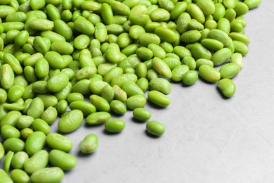 Photo of Fresh edamame soybeans on grey textured table, closeup