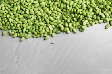 Photo of Fresh edamame soybeans on grey textured table, top view. Space for text