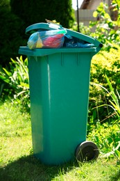 Trash bags full of garbage in bin outdoors