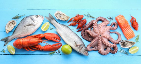 Different sea food on light blue wooden table, flat lay