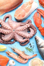 Photo of Different sea food on light blue wooden table, flat lay