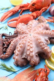 Different sea food on light blue wooden table, closeup