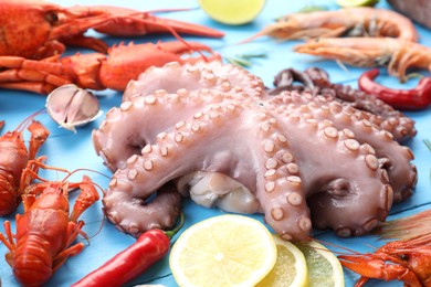 Different sea food on light blue wooden table, closeup