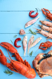 Different sea food on light blue wooden table, flat lay