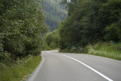 Photo of Beautiful view of green trees and asphalt road in mountains