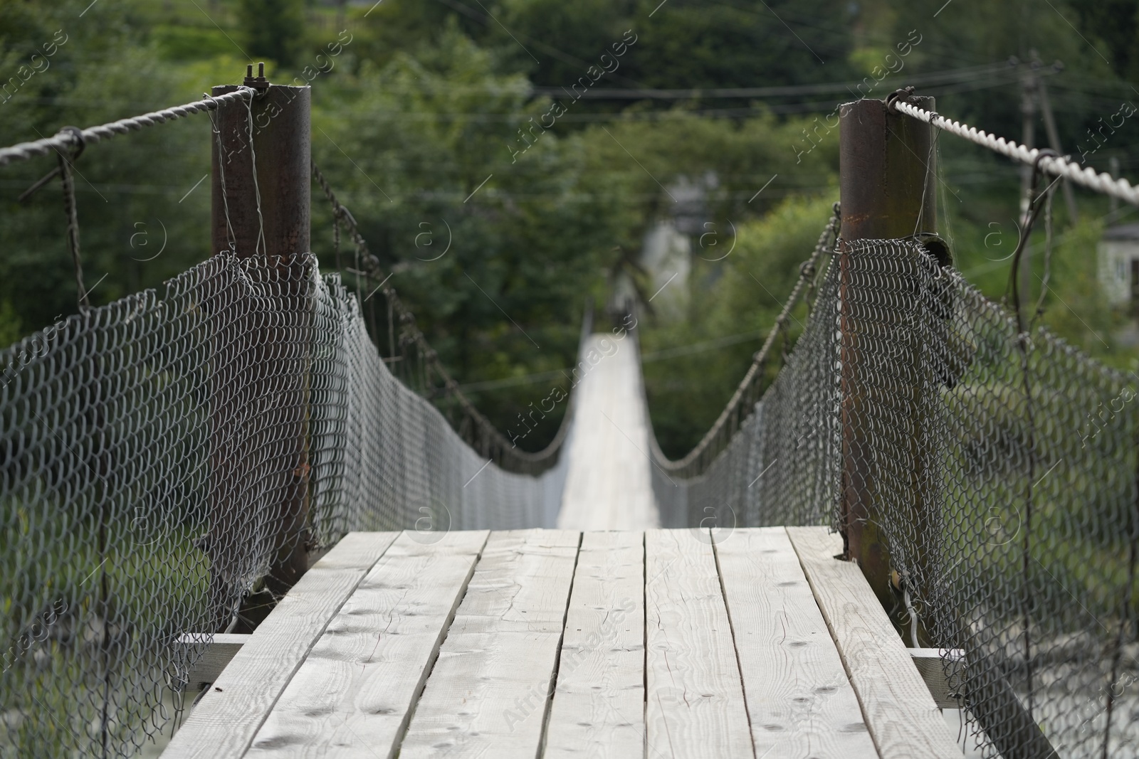 Photo of View of long wooden suspension bridge outdoors