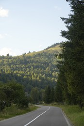 Photo of Beautiful view of green trees and asphalt road in mountains