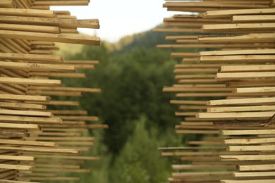 Stacks of many wooden planks outdoors, closeup