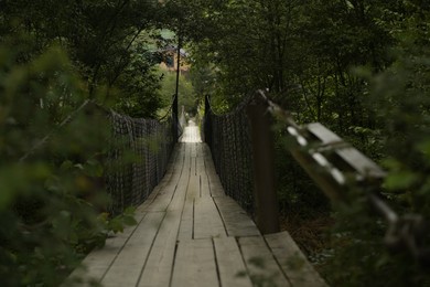 Photo of View of long wooden suspension bridge outdoors