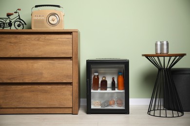 Mini refrigerator with different drinks and snacks indoors