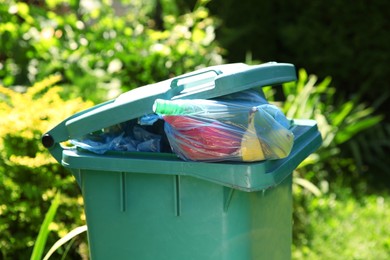 Photo of Trash bags in garbage bin outdoors, closeup