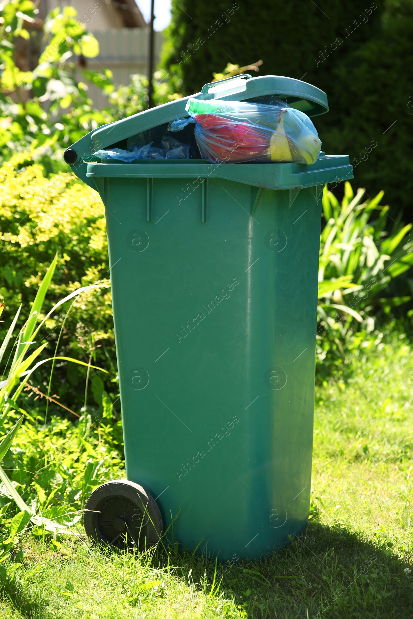 Photo of Trash bags full of garbage in bin outdoors