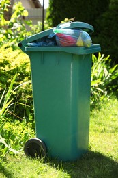 Trash bags full of garbage in bin outdoors