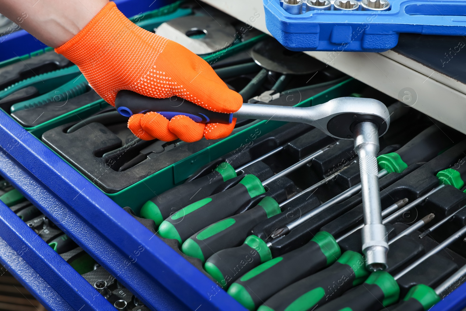 Photo of Auto mechanic with torque wrench and different tools at automobile repair shop, closeup