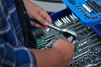 Photo of Auto mechanic with torque wrench at automobile repair shop, closeup