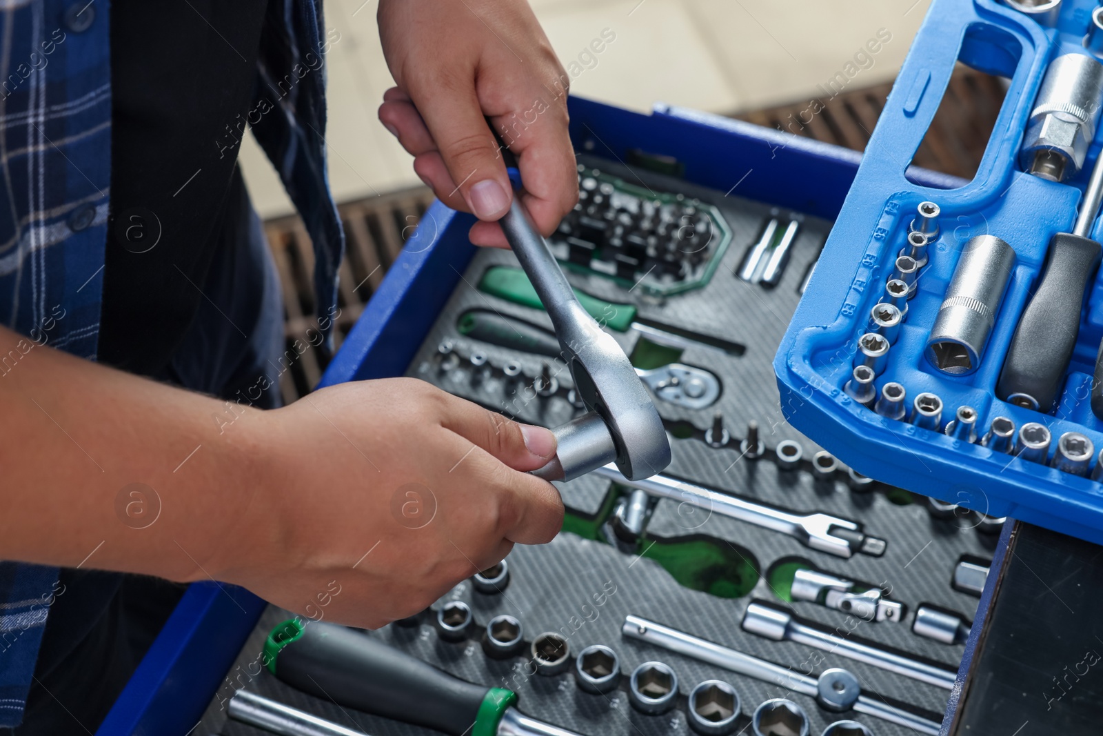 Photo of Auto mechanic with torque wrench at automobile repair shop, closeup