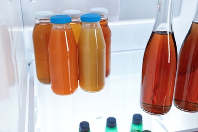 Photo of Many bottles of juice in refrigerator, closeup