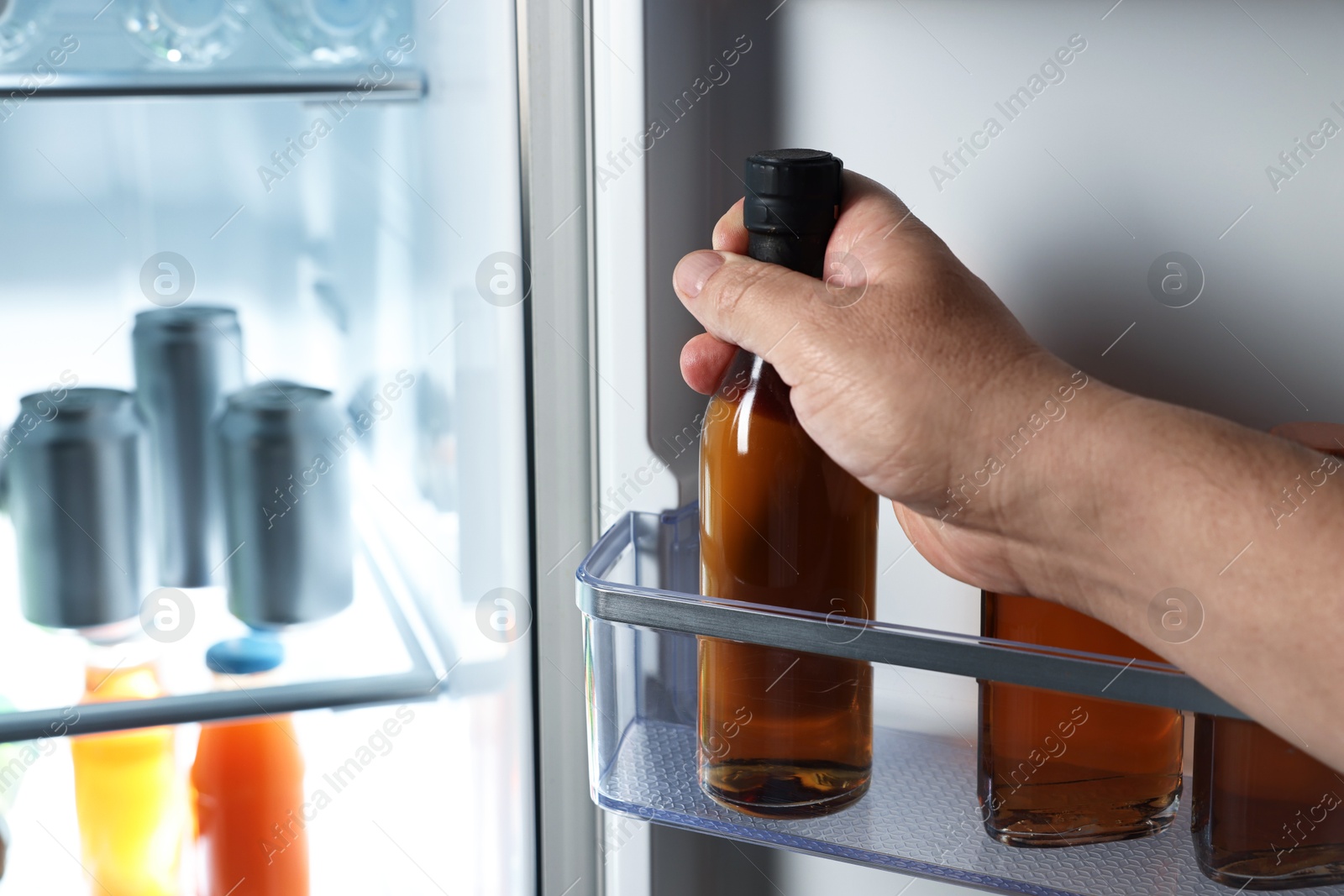 Photo of Woman taking bottle with drink from refrigerator, closeup