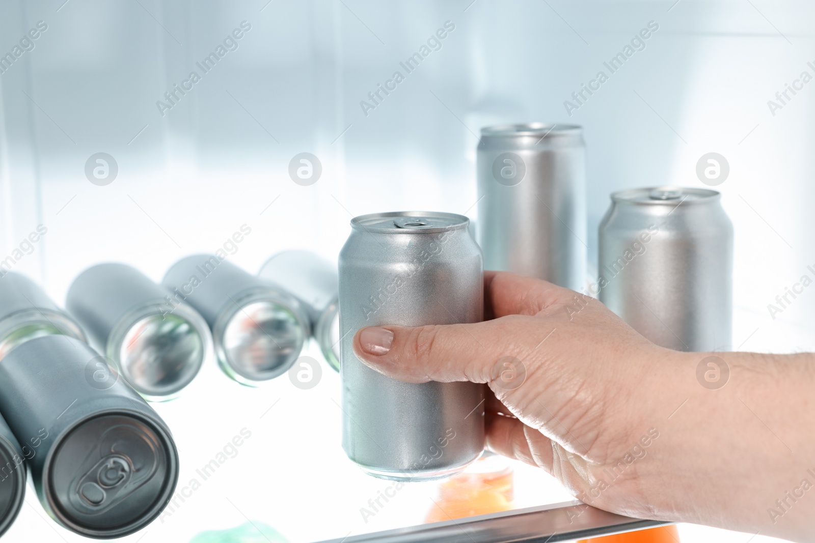 Photo of Woman taking can of beer from refrigerator, closeup