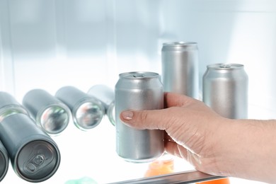 Woman taking can of beer from refrigerator, closeup