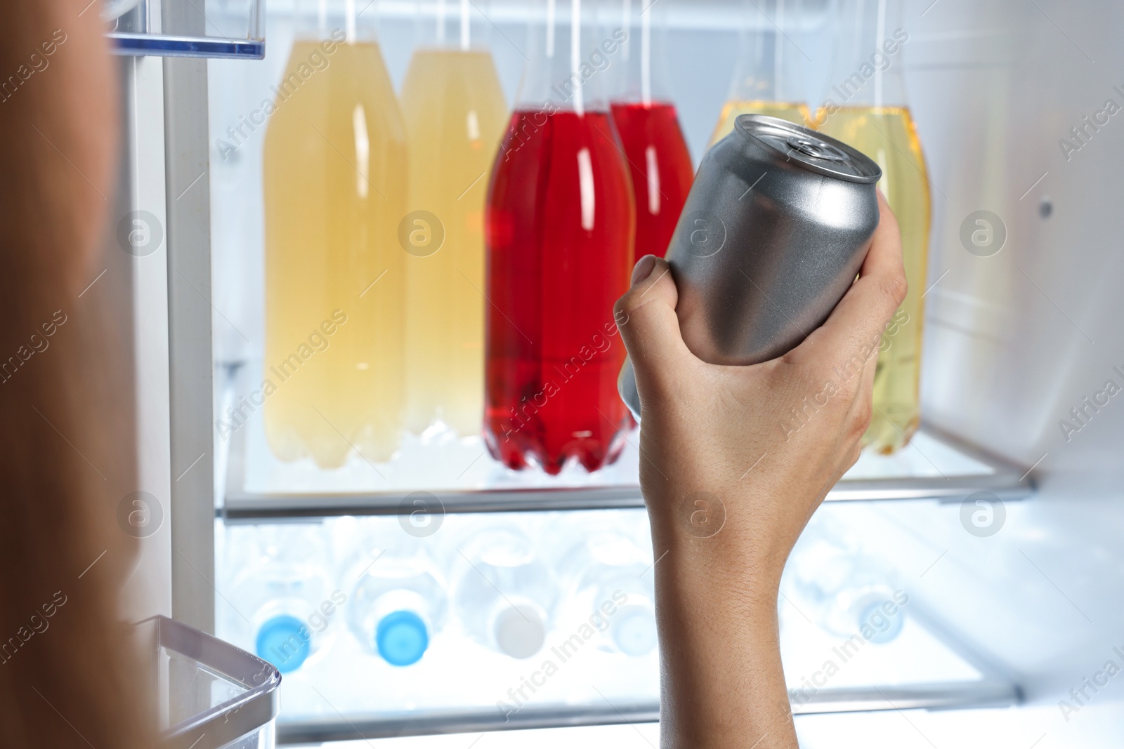 Photo of Woman taking bottle with drink from refrigerator, closeup