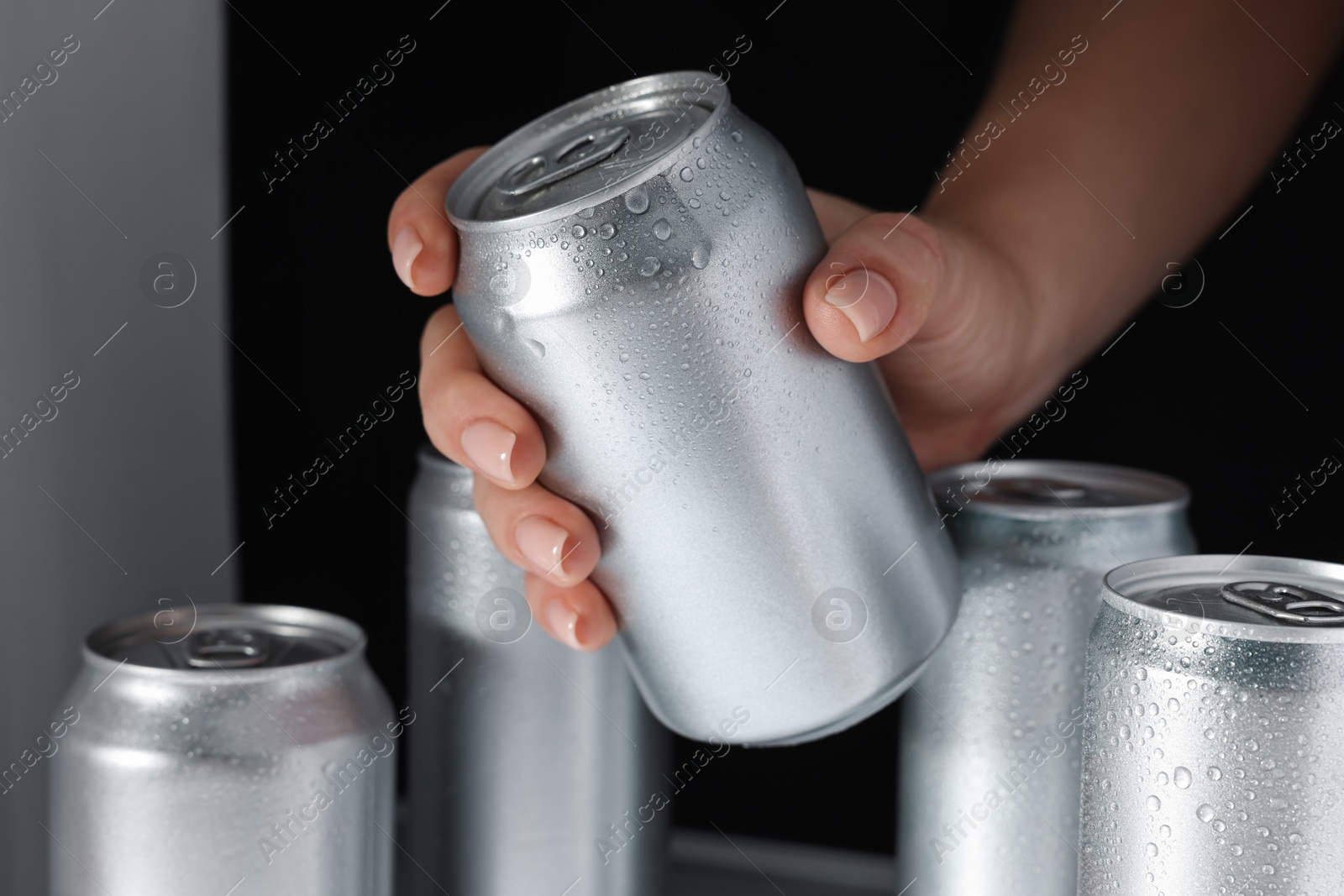 Photo of Woman taking can of beer from refrigerator, closeup