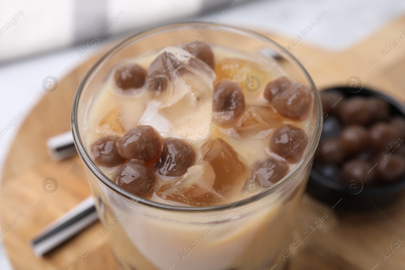 Photo of Tasty milk bubble tea in glass on table, closeup