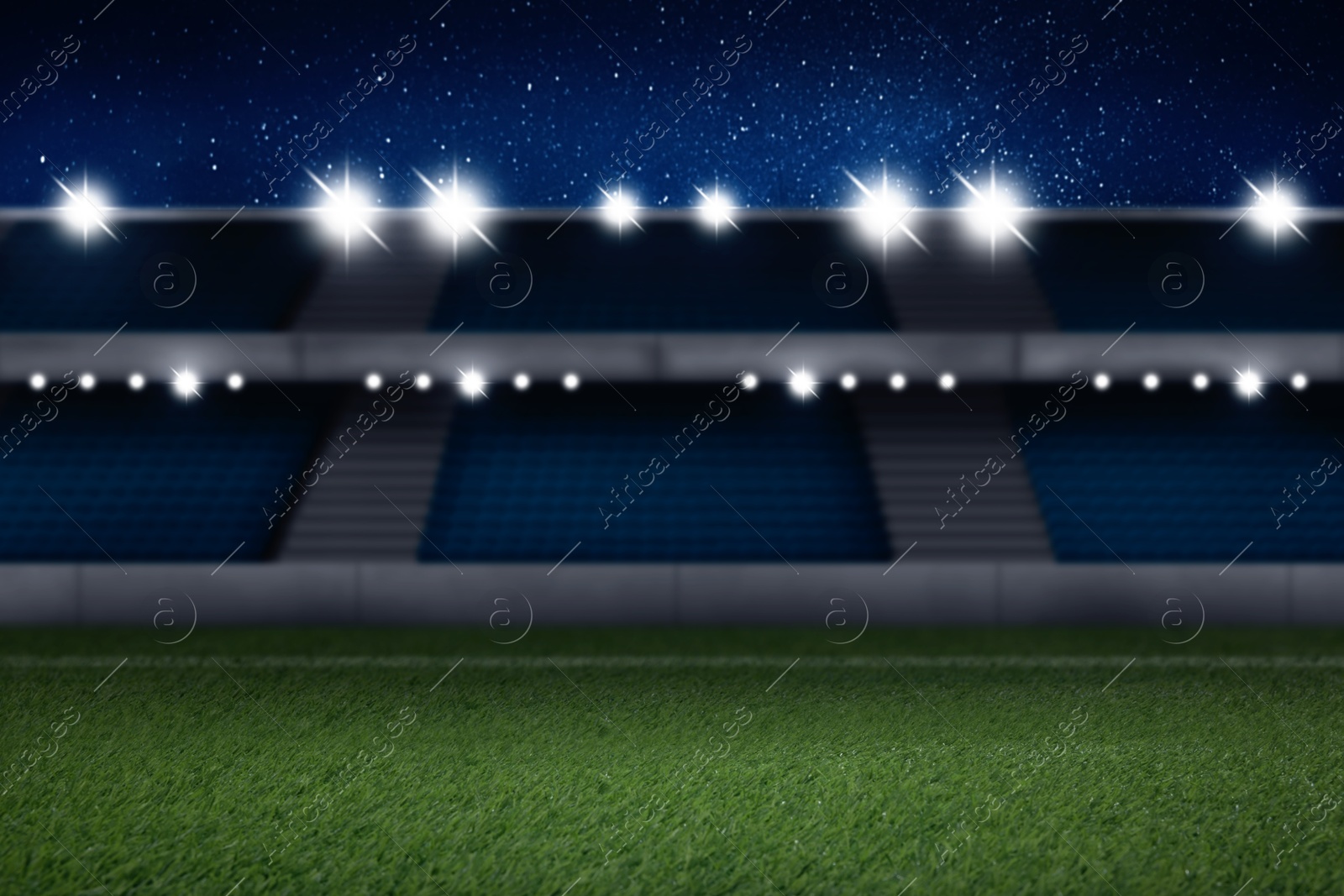 Image of Football stadium with seats, illumination and green grass