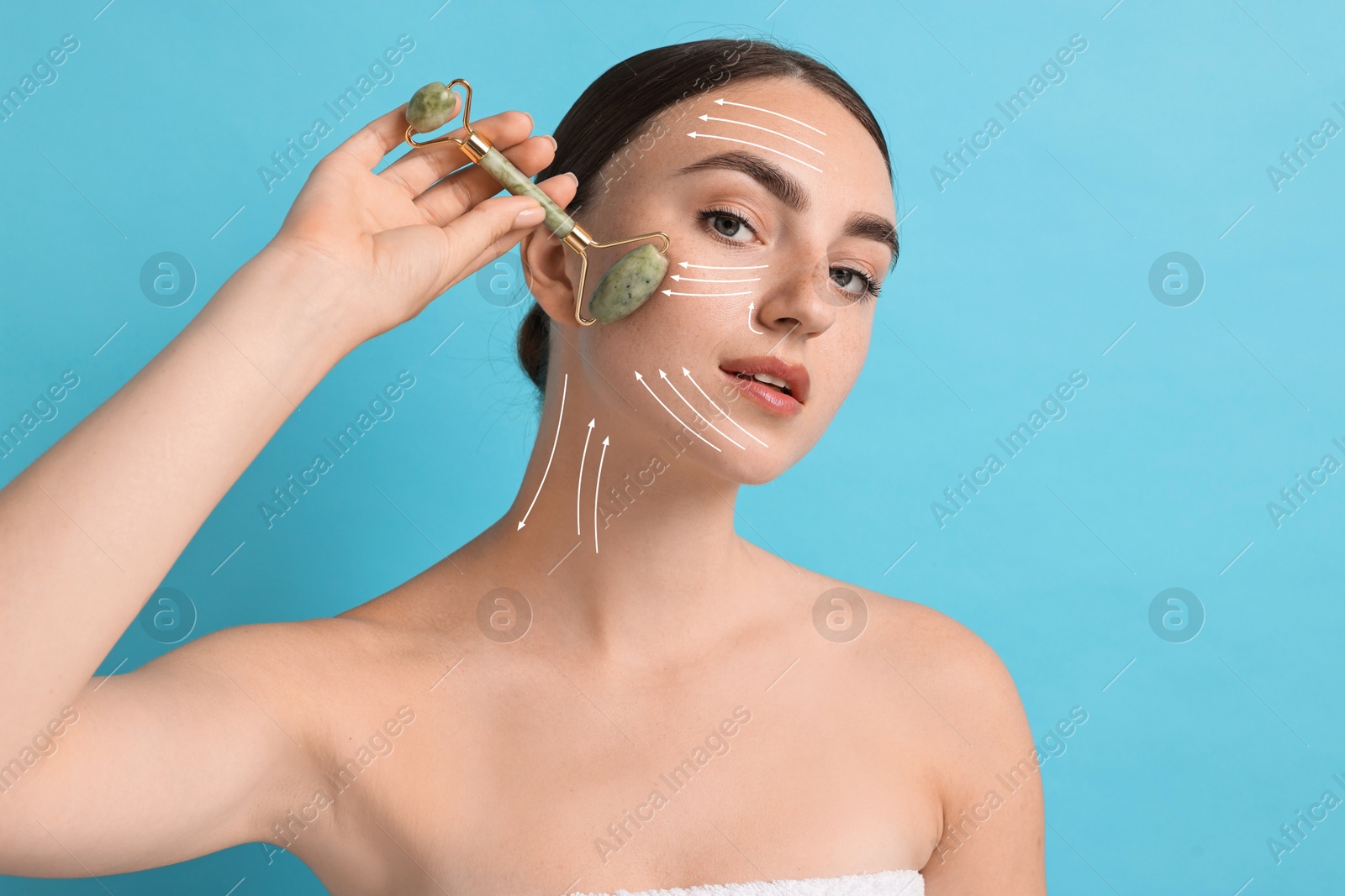 Image of Beautiful young woman doing facial massage with roller on light blue background. Lines on skin showing directions of motion