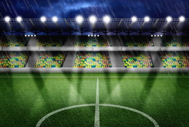 Image of Football stadium with seats, illumination and green grass