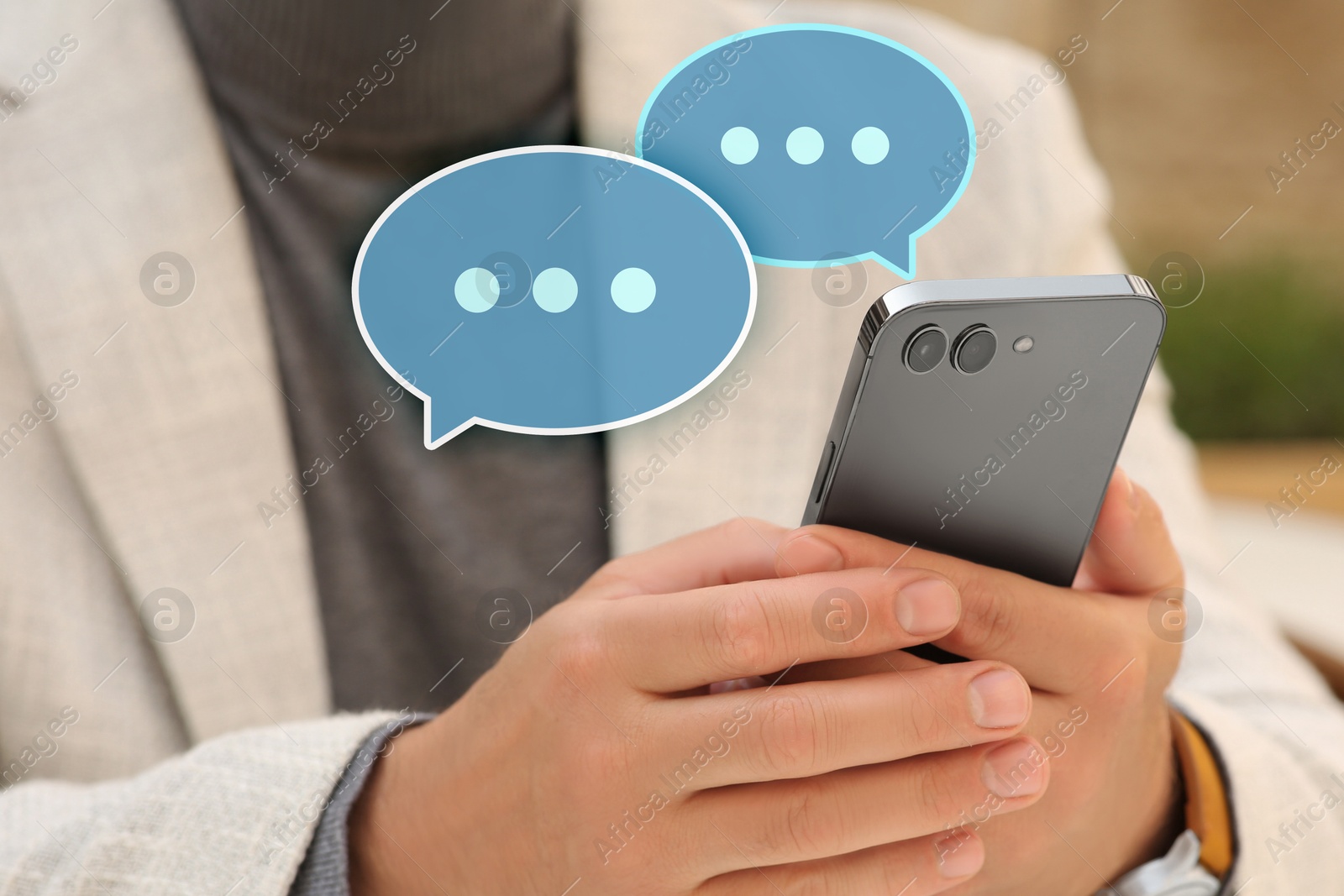 Image of Man using messaging application on smartphone indoors, closeup. Speech bubbles