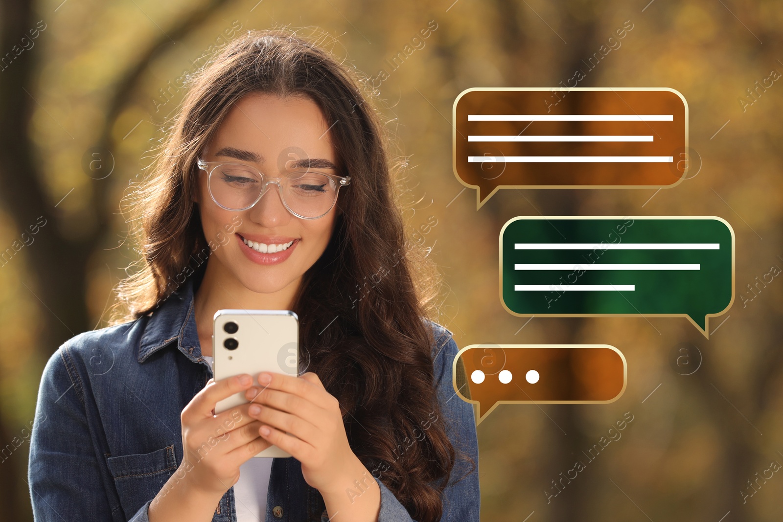 Image of Happy woman sending message via smartphone outdoors. Different speech bubbles near her