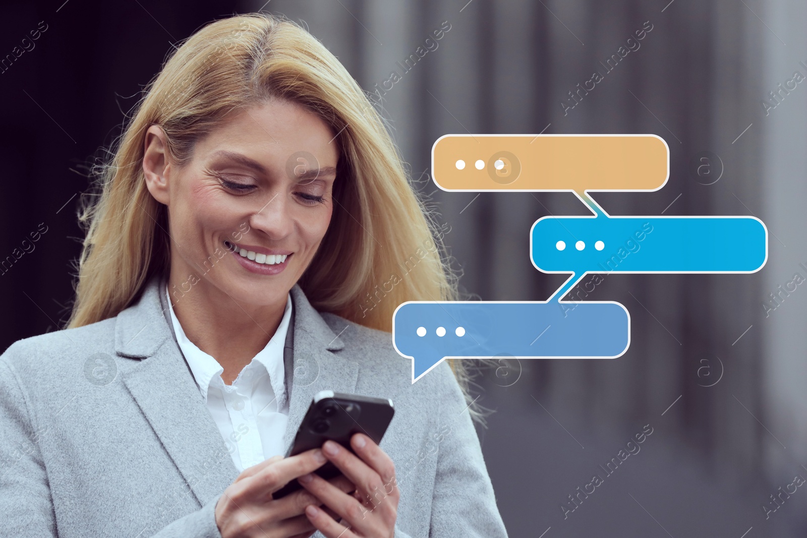 Image of Happy businesswoman sending message via smartphone on outdoors. Speech bubbles near device