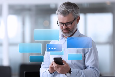 Image of Businessman sending message via smartphone in office. Speech bubbles near device