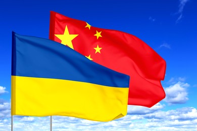 Image of Flags of Ukraine and China against sky. Diplomatic international relations