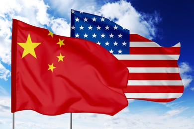 Image of Flags of China and USA against sky. Diplomatic international relations