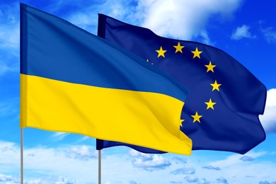 Flags of Ukraine and European Union against sky. Diplomatic international relations