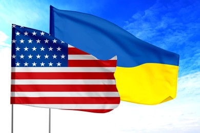 Image of Flags of USA and Ukraine against sky. Diplomatic international relations