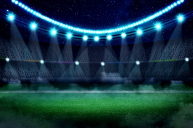 Image of Football stadium with seats, illumination and green grass