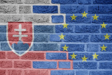 Image of Flags of European Union and Slovakia painted on old brick wall