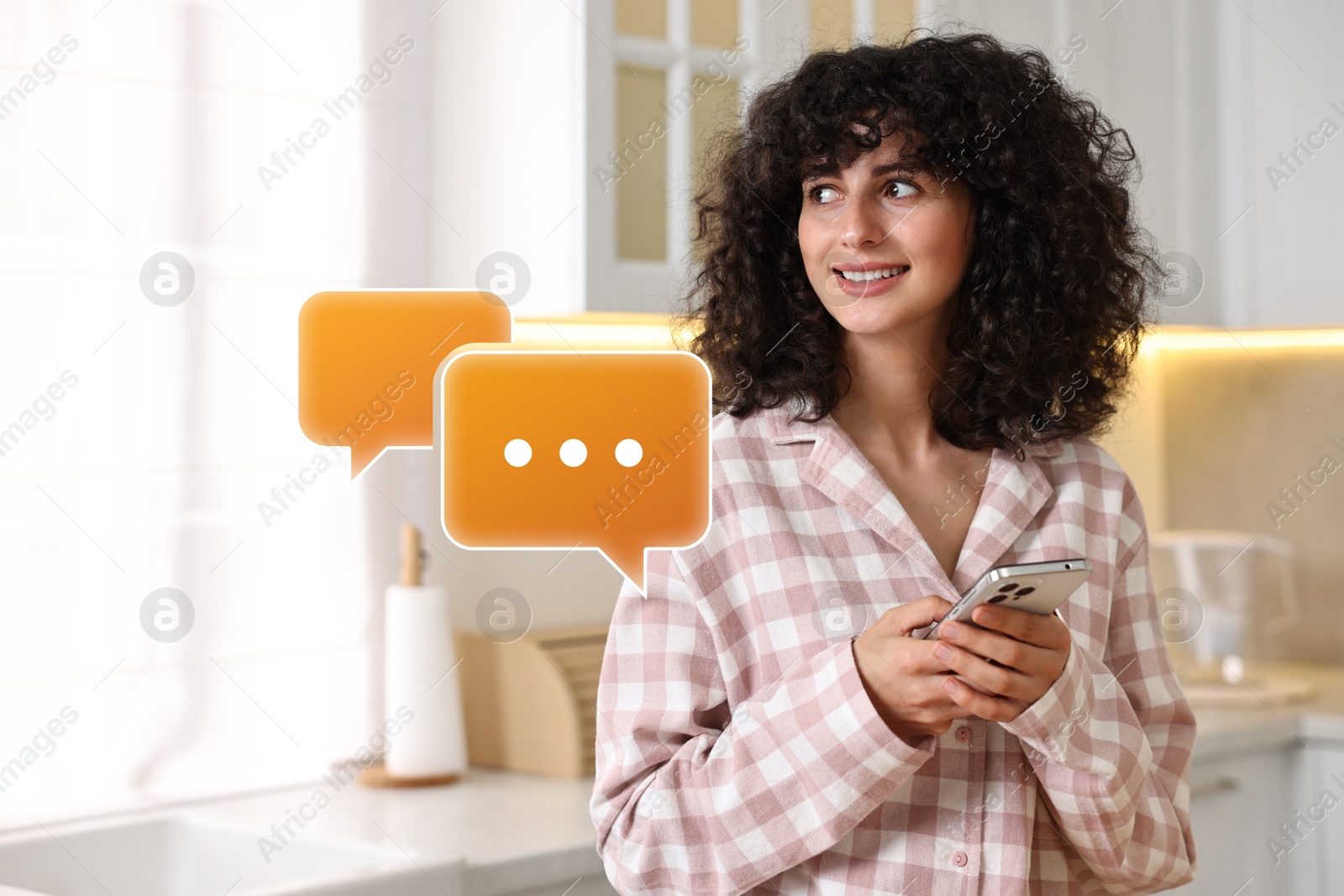 Image of Happy woman waiting for message on smartphone in kitchen. Speech bubbles near her