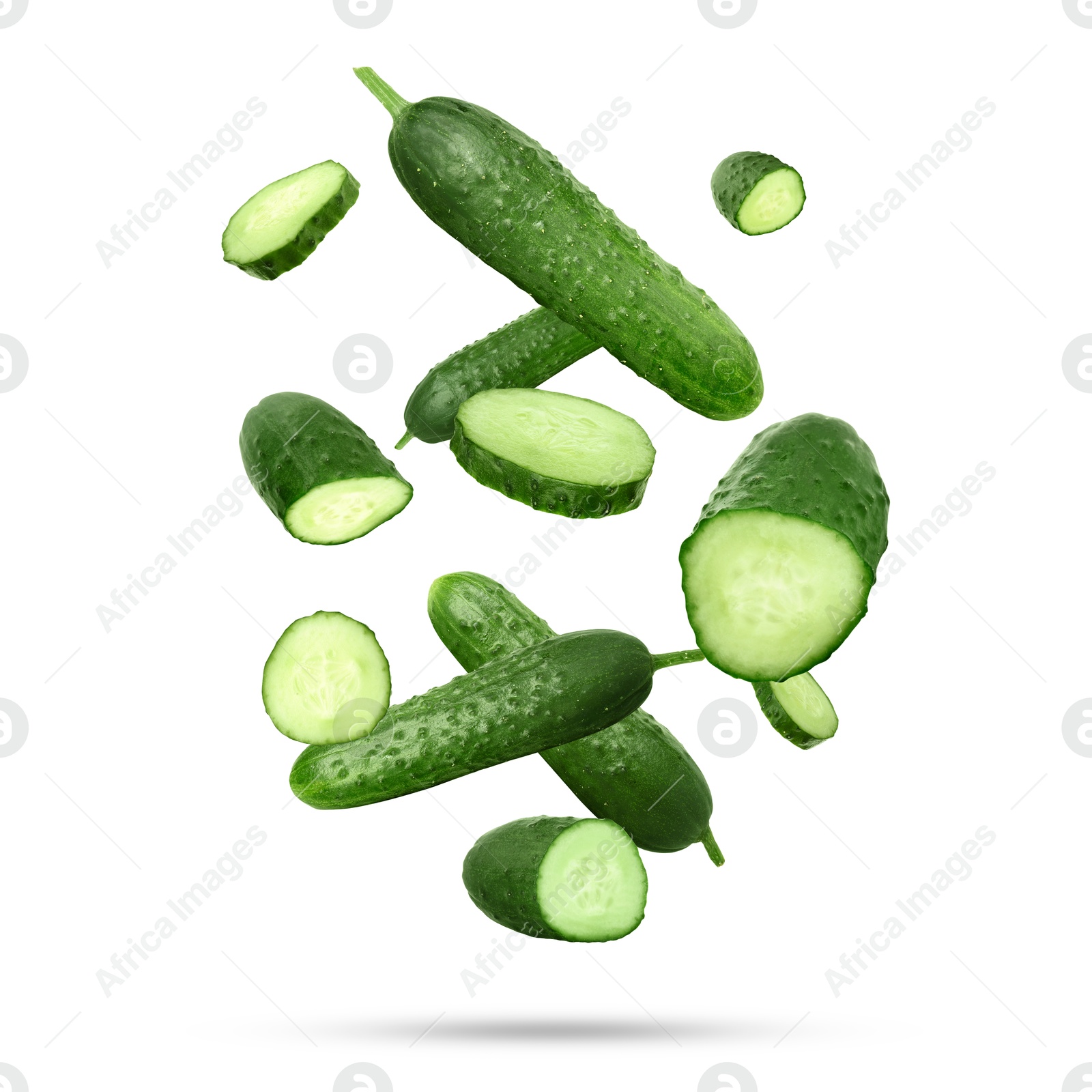 Image of Many ripe cucumbers falling on white background