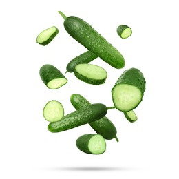 Image of Many ripe cucumbers falling on white background