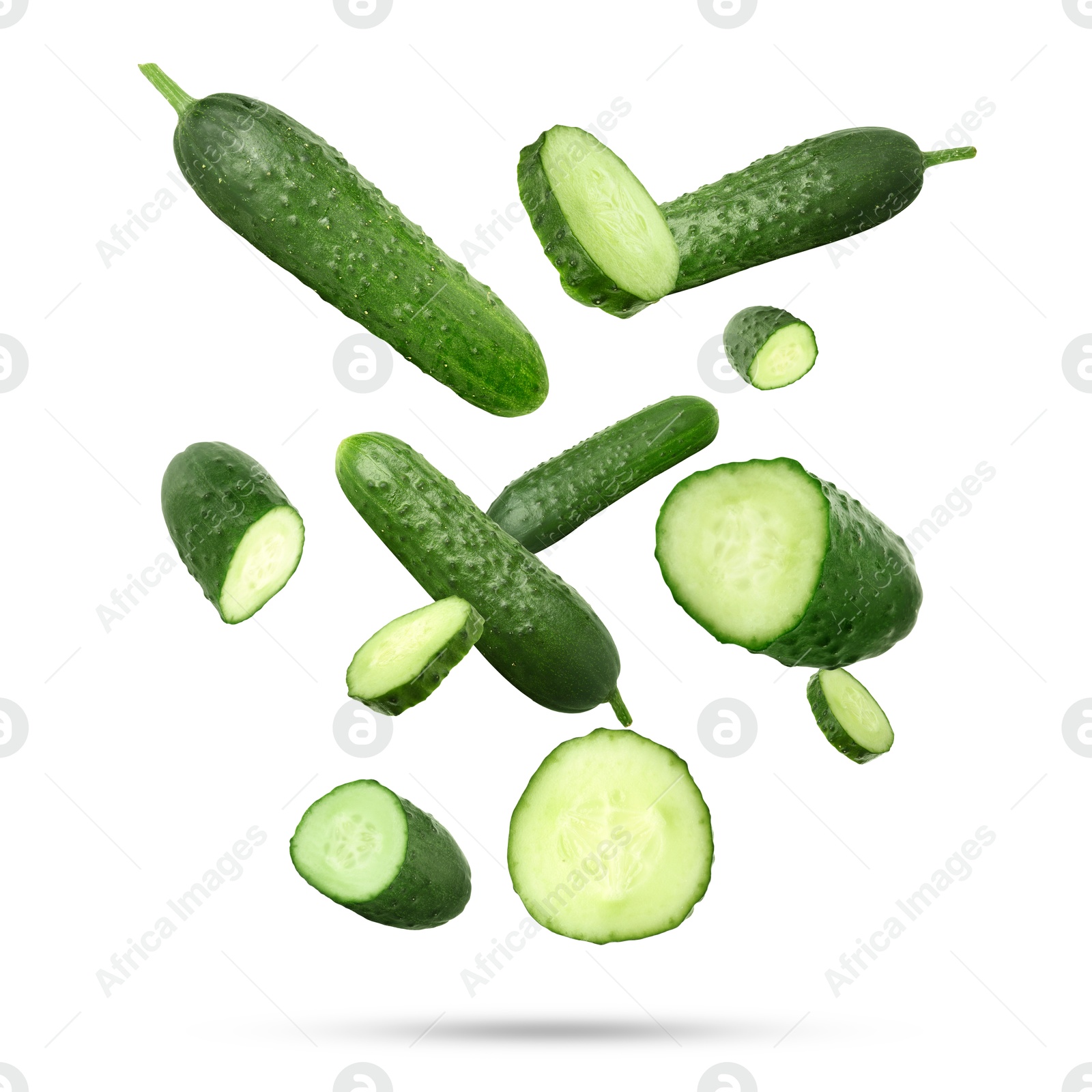 Image of Many ripe cucumbers falling on white background