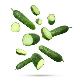 Image of Many ripe cucumbers falling on white background