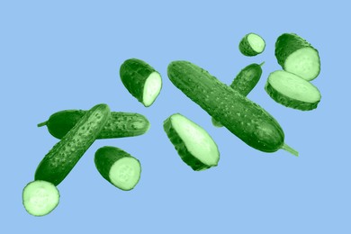 Image of Many ripe cucumbers flying on light blue background