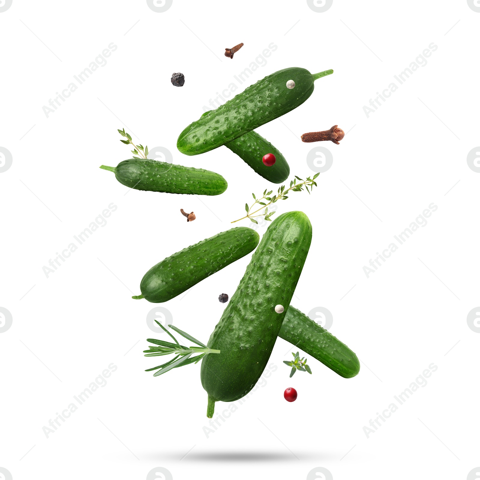 Image of Ripe cucumbers, herbs and spices falling on white background