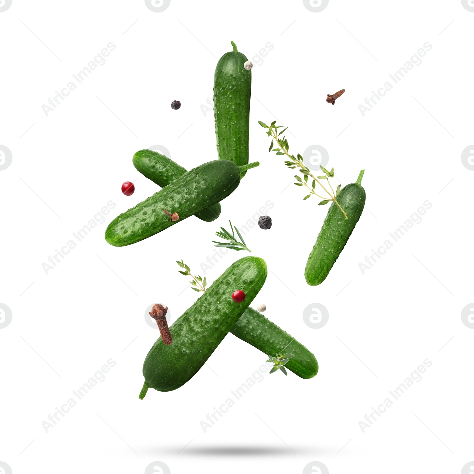 Image of Ripe cucumbers, herbs and spices falling on white background